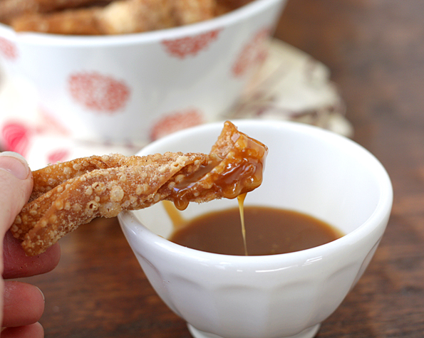 Dipping churro wonton in salted butter caramel sauce