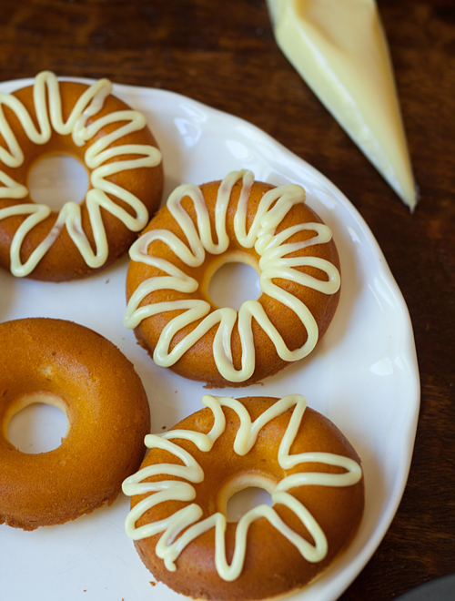 Drizzling white chocolate on donuts