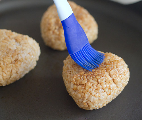 Brush the toasted rice balls with soy sauce