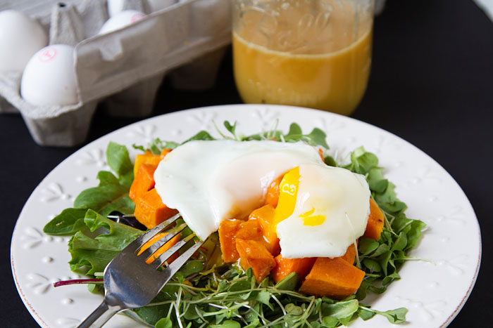 Fried egg on roasted sweet potato and baby greens salad