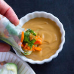 Dipping fresh spring rolls in Easy Peanut Sauce