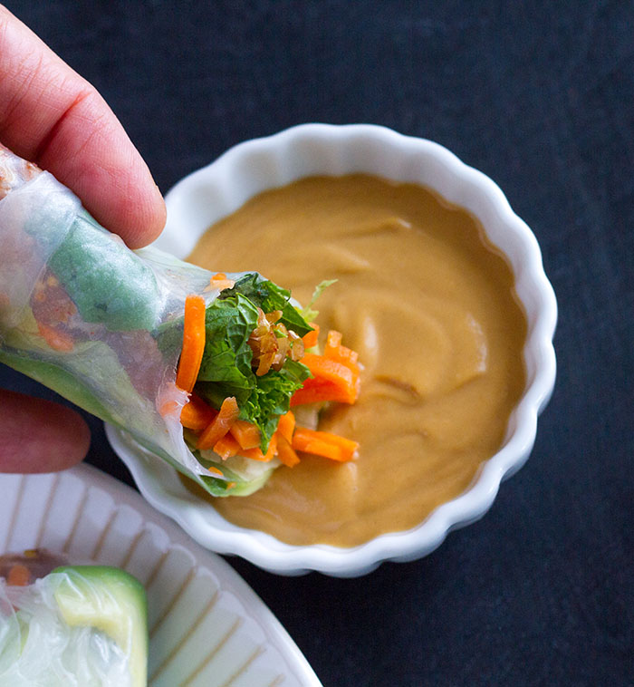 Dipping fresh spring rolls in Easy Peanut Sauce
