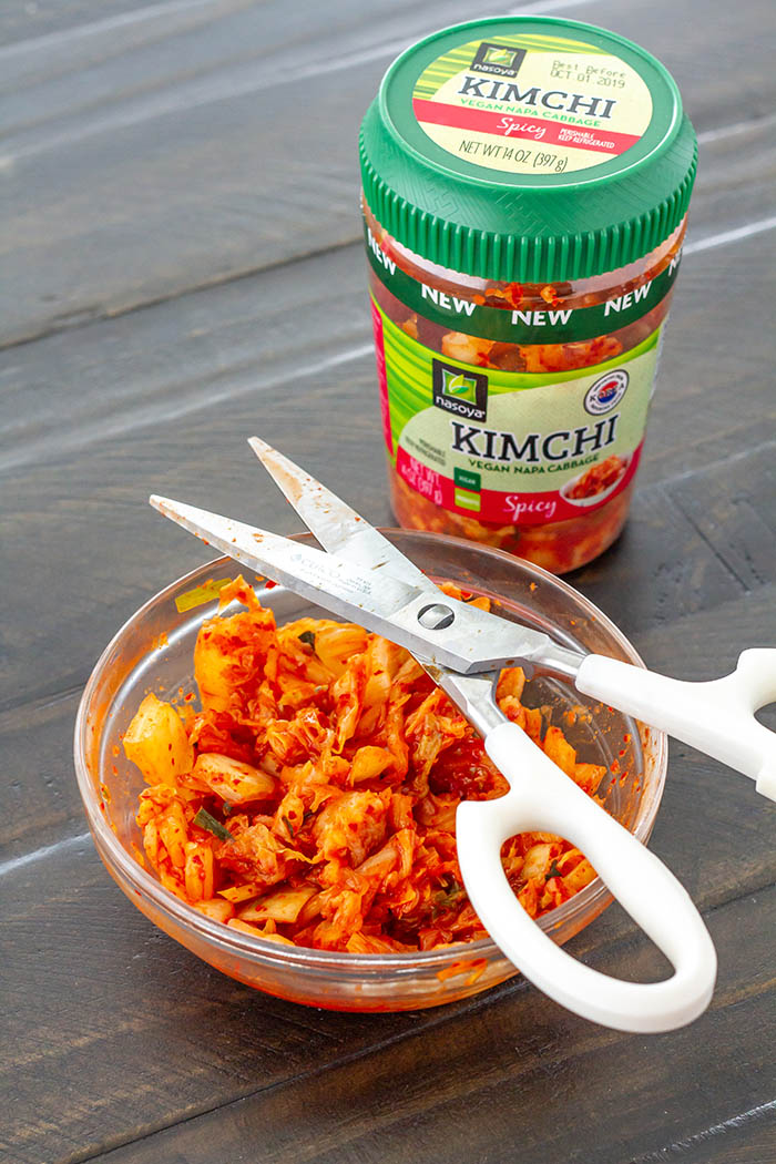 Cutting Nasoya Spicy Napa Cabbage Kimchi with kitchen shears