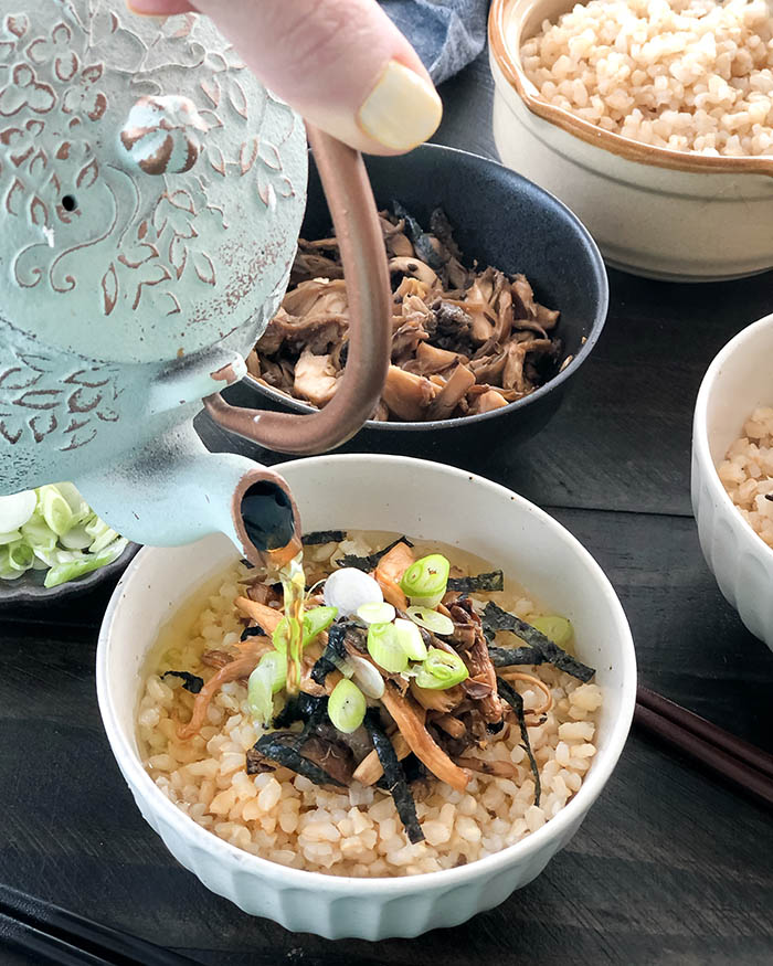 Pouring soba cha over rice and cooked mushrooms