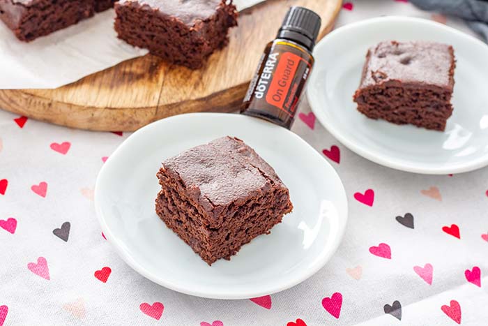 Squares of Fudgy Spiced Brownies with a bottle of doTERRA OnGuard oil, which is one of the ingredients