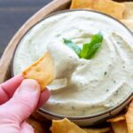 Bowl of lemon basil white bean dip with pita chips